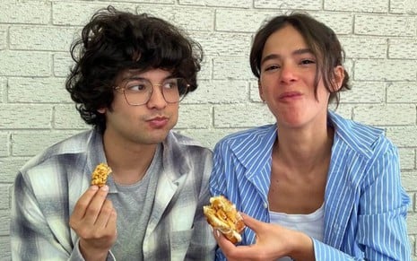 Xolo Maridueña e Bruna Marquezine comem sanduíches em foto