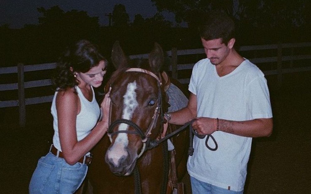 Imagem de Bruna Marquezine (à esq.) e Enzo Celulari fazendo carinho em um cavalo