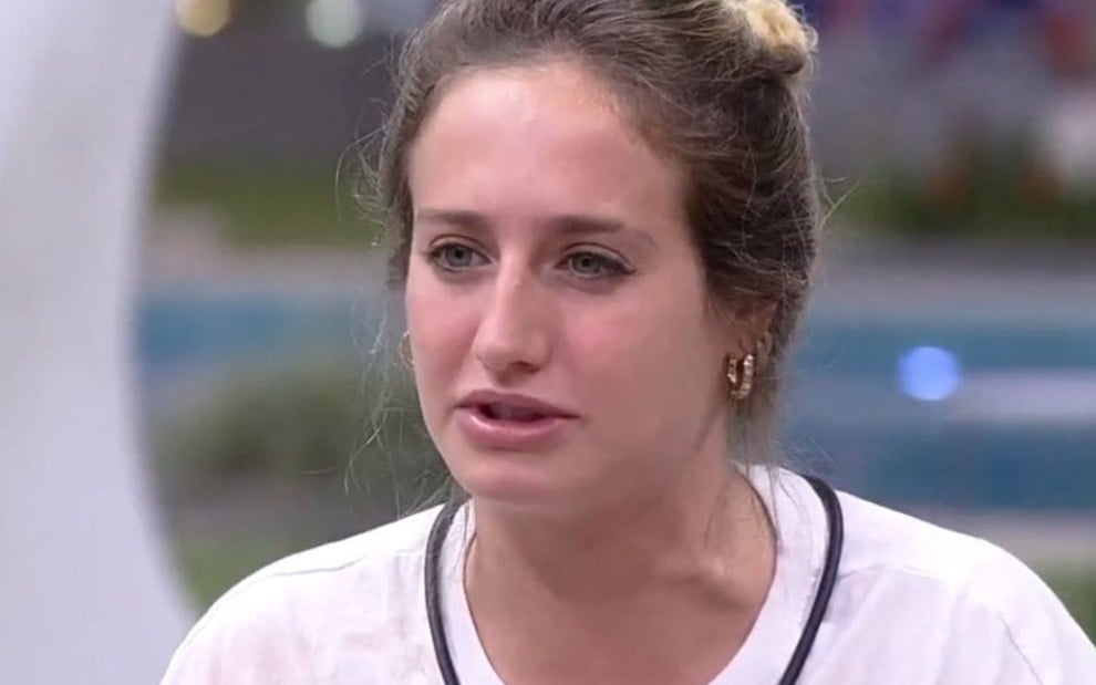 Bruna Griphao no jardim do BBB 23; ela tem a expressão séria e usa uma camiseta branca