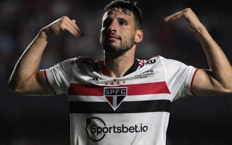 Calleri, atacante do São Paulo, gritando para o alto com uniforme branco com faixas preta e vermelha