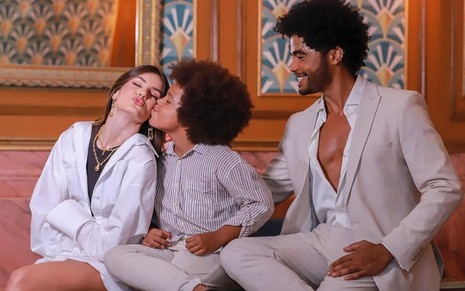 No lançamento de Amor Perfeito, Levi Asaf dá um beijo no rosto de Camila Queiroz; Diogo Almeida está ao lado e observa