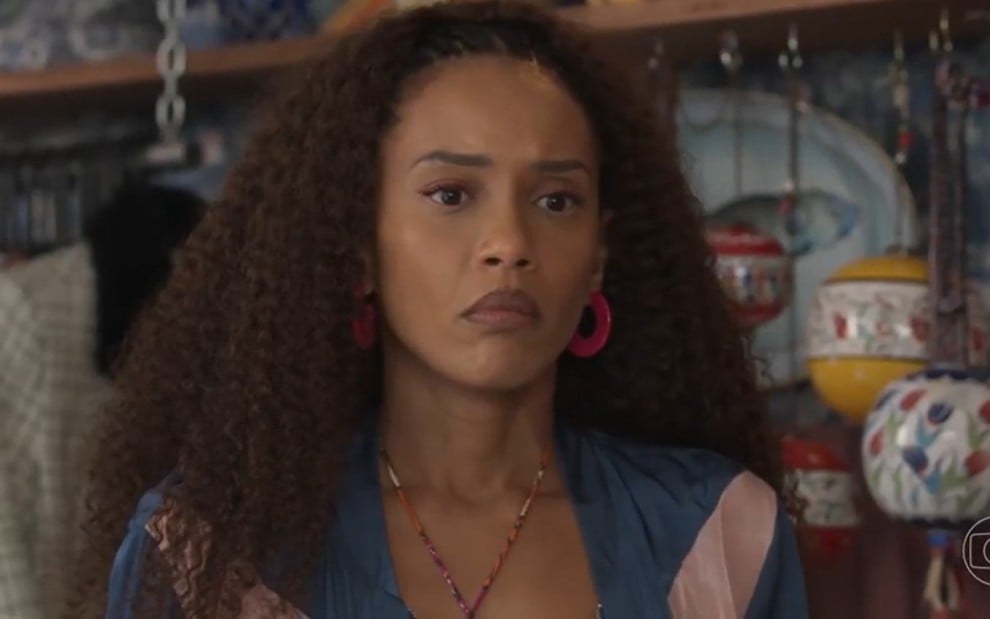 A atriz Taís Araujo com expressão séria em cena da novela Cara e Coragem