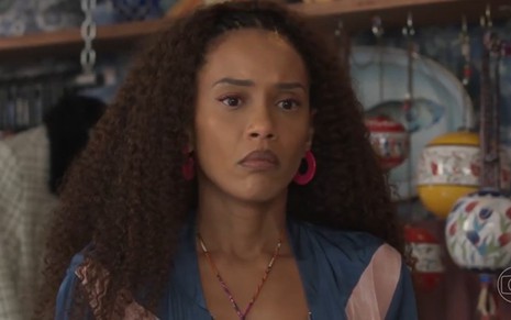 A atriz Taís Araujo com expressão séria em cena da novela Cara e Coragem