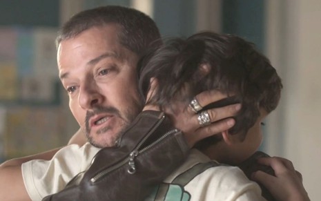 Moa (Marcelo Serrado) abraça Chiquinho (Guilherme Tavares) em cena de Cara e Coragem