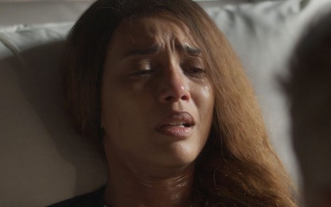 A atriz Taís Araujo como Clarice em Cara e Coragem; ela está deitada em uma cama e chorando