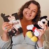 Carina Rissi segura o livro Perdida em uma mão e um boneco do Mickey em outra