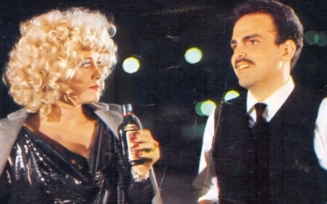 A atriz Darlene Glória e o ator Guilherme Karan (1957-2016) em cena da novela Carmem (1987).ela com garrafa de bebida na mão, cena noturba