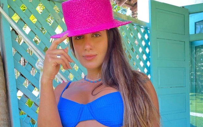 Carol Peixinho de boné rosa e biquíni azul; ex-participante do Big Brother Brasil faz carão