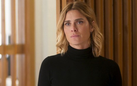 Em cena de Vai na Fé, Carolina Dieckmann usa blusa preta e está com a expressão séria