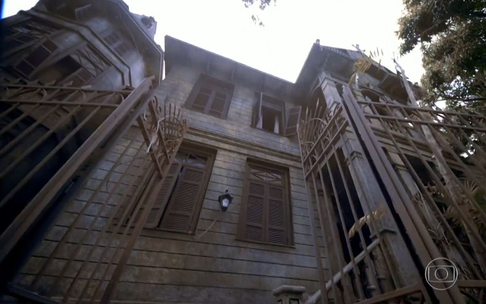 Casa abandonada do cenário da novela Alto Astral, produzida em 2014 pela TV Globo; a foto mostra quatro janelas e o portão de entrada do casarão