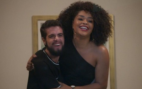 Animado e sorridente, Catatau (Bernardo de Assis) abraça Renatinha (Juliana Alves) em cena de Salve-se Quem Puder