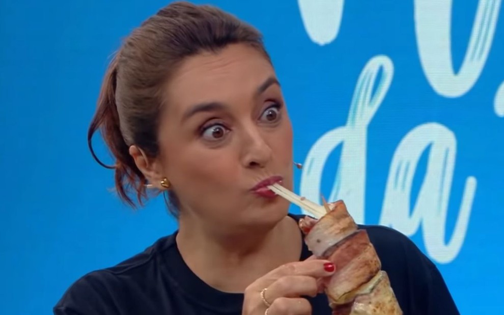 Imagem de Catia Fonseca comendo kafta enrolada no bacon durante Melhor da Tarde