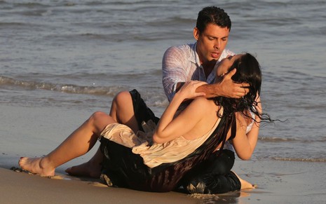 Cauã Reymond segura Alinne Moraes, que está desmaiada após quase se afogar, em gravação da novela Um Lugar ao Sol em praia