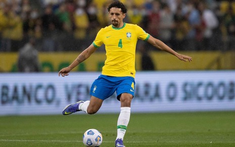 Jogador Marquinhos, do Brasil, vestindo uniforme verde, amarelo e azul, com a bola aos pés durante partida