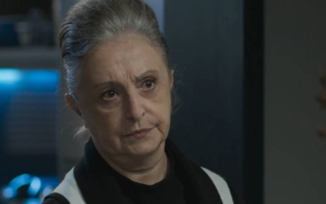 Atriz Ana Lucia Torre olha para frente com cara de séria em cena de Quanto Mais Vida, Melhor
