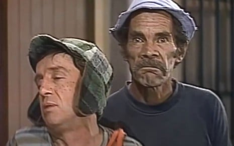 Em cena de Chaves, o personagem Roberto Bolaños fala enquanto Seu Madruga (Ramón Valdés) fecha a cara para a câmera