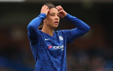 Atacante Sam Kerr, do Chelsea, com uma camisa azul do clube e coçando a cabeça durante um jogo do clube inglês