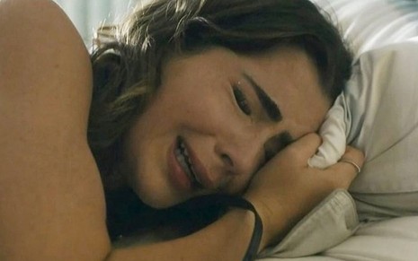 Em cena de Travessia, Jade Picon chora abraçada a um travesseiro
