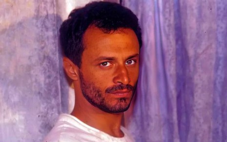 O ator Chiquinho Brandão sério em foto de divulgação da minissérie O Sorriso do Lagarto (1991)
