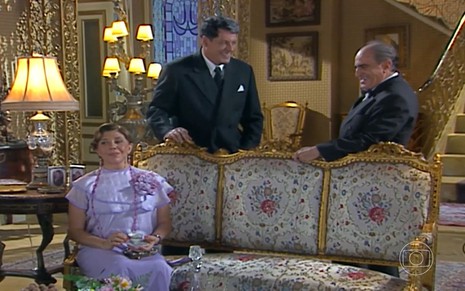 Os atores Tânia Bondezan (sentada), Antônio Grassi (em pé, à esquerda) e Ary Fontoura (em pé, à direita) em cena de Chocolate com Pimenta; ela está sentada enquanto os dois, atrás, conversam olhando um para o outro e sorrindo
