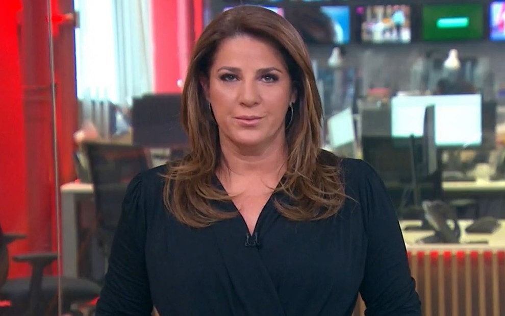 Christiane Pelajo veste uma roupa preta enquanto apresenta o Edição das 16h na GloboNews