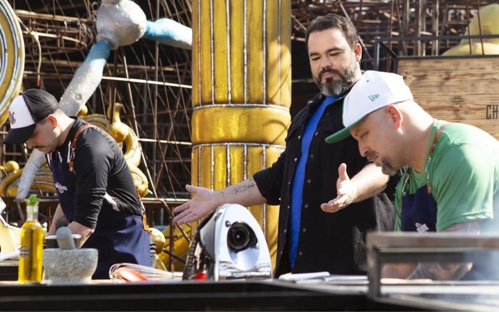 Imagem do chef Rick Bolzani orientando participantes do reality show Churrasqueiros, do Space