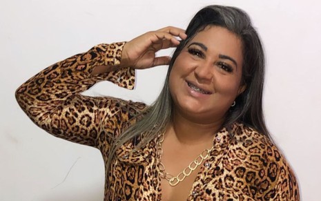 Imagem de Cida Santos de cabelo solto e camisa estampada com animal print