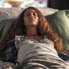 Taís Araujo está deitada em um leito de hospital gravando cena como Clarice de Cara e Coragem