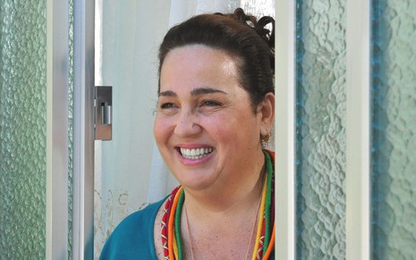 Claudia Jimenez sorridente em cena da novela Aquele Beijo (2011), da Globo