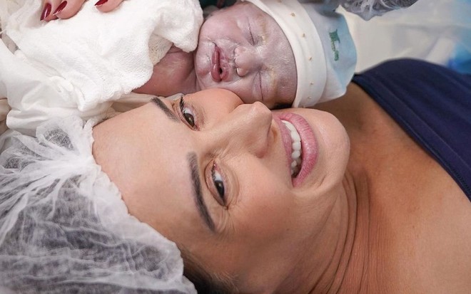 Luca, que acabou de nascer, está entre Claudia Raia e Jarbas Homem de Mello ainda na sala de parto