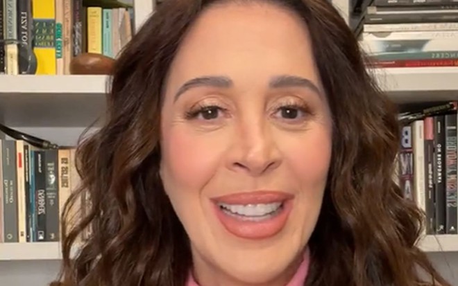 A atriz Claudia Raia; ela está sentada, olhando para a frente e sorrindo durante uma live