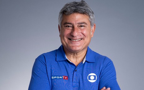 Cleber Machado com uma blusa azul e sorriso em foto na Globo