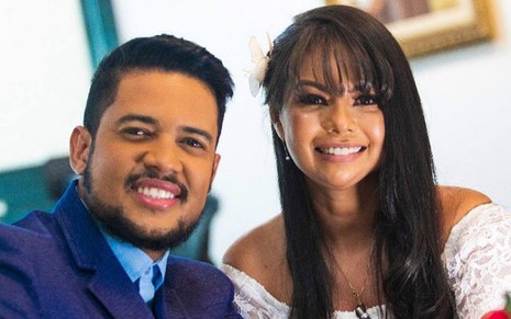 Foto de Clevinho ao lado de Paulinha Abelha; ele veste terno azul, e ela usa um vestido branco