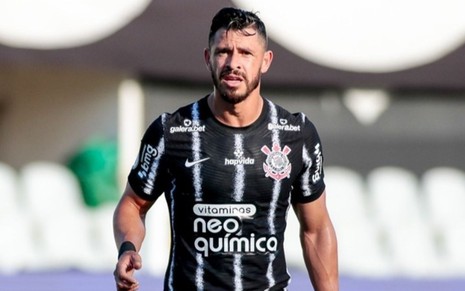 Jogador Giuliano, do Corinthians, veste uniforme preto com listras brancas durante partida da equipe paulista