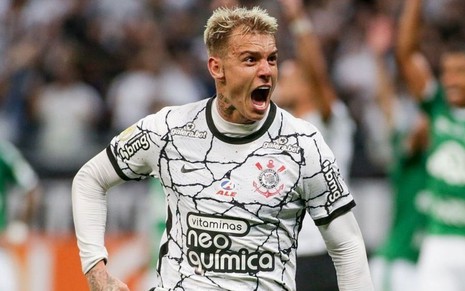 Jogador Róger Guedes, do Corinthians, veste uniforme branco com detalhes pretos e comemora gol feito