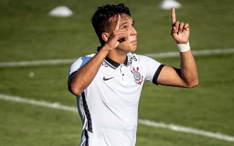 Jogador Giovane, do Corinthians, veste uniforme branco com detalhes pretos e comemora gol pelo time
