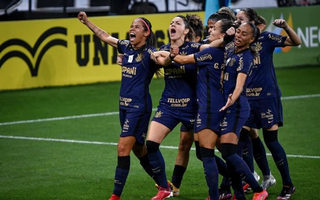 Gabi Portillo e outras jogadoras do Corinthians, usando uma camiseta roxa do clube, comemoram um gol contra o Palmeiras na Neo Quimica Arena