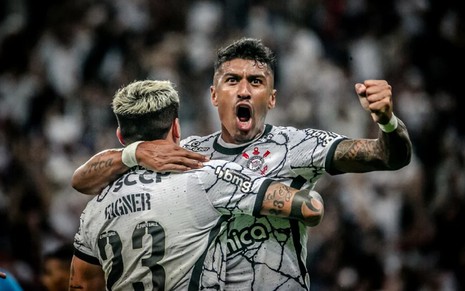 Com a camisa branca do Corinthians, Paulinho é abraçado por Fagner e vibra após gol