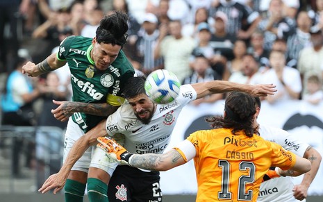 Jogadores do Palmeiras e do Corinthians tentam cabecear bola; Cássio, de costas, observa a disputa