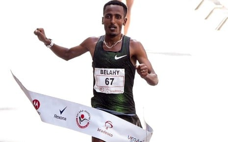 Belahy Bezabh, da Etiópia, usa um macacão verde e celebra vitória da Corrida de São Silvestre