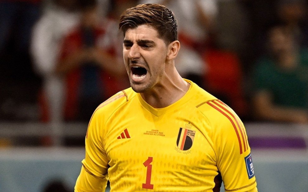 Thibaut Courtois, da Bélgica, em campo pela seleção com uniforme amarelo com detalhes vermelhos