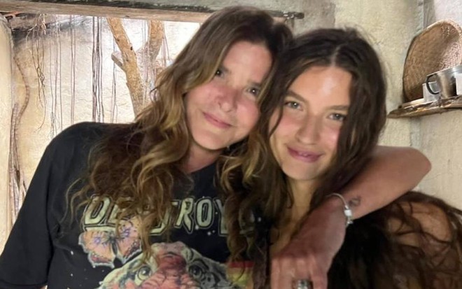 Cristiana Oliveira entrelaça o braço em Alanis Guillen no cenário de Pantanal