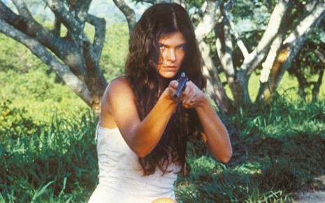 Cristiana Oliveira como Juma Marruá com uma espingarda na mão em cena de Pantanal, da Manchete