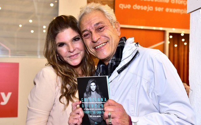 Paulo Gorgulho surge ao lado de Cristiana Oliveira enquanto segura livro