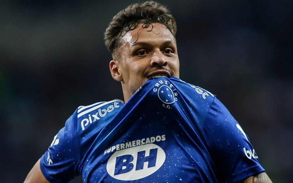 Daniel Júnior, do Cruzeiro, morde camisa azul com detalhes brancos ao comemorar gol pela equipe