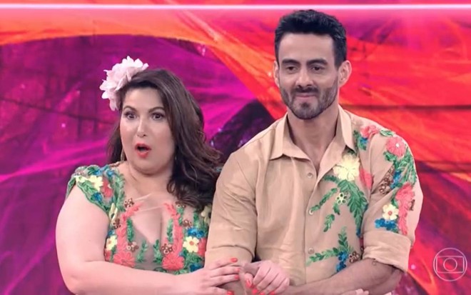 A atriz Mariana Santos com boca aberta ao lado do professor de dança Léo Santos, sério, no cenário da Dança dos Famosos de 2017