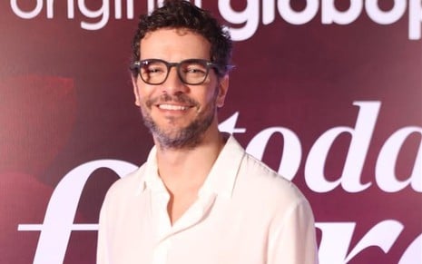 Daniel de Oliveira posa na festa de Todas as Flores usando óculos e blusa branca