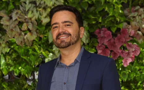 Autor de novelas Daniel Ortiz usa roupa social azul em foto de divulgação da Globo