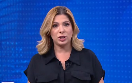 Daniela Lima com uma camisa preta e expressão séria no CNN 360