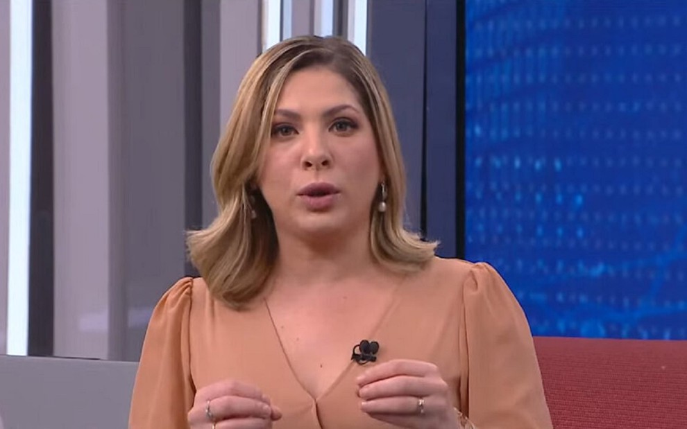 Daniela Lima de vestido bege apresentando o programa CNN 360